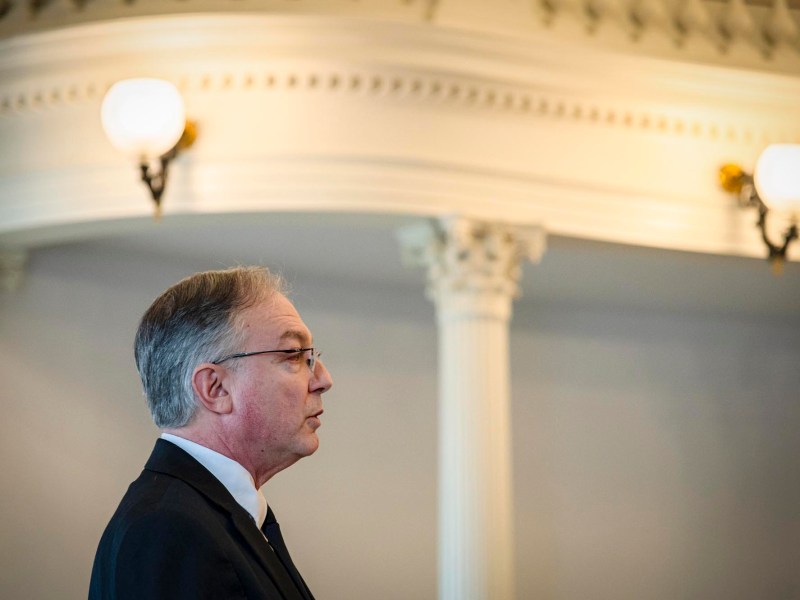 A man in a suit and tie is standing in a room.