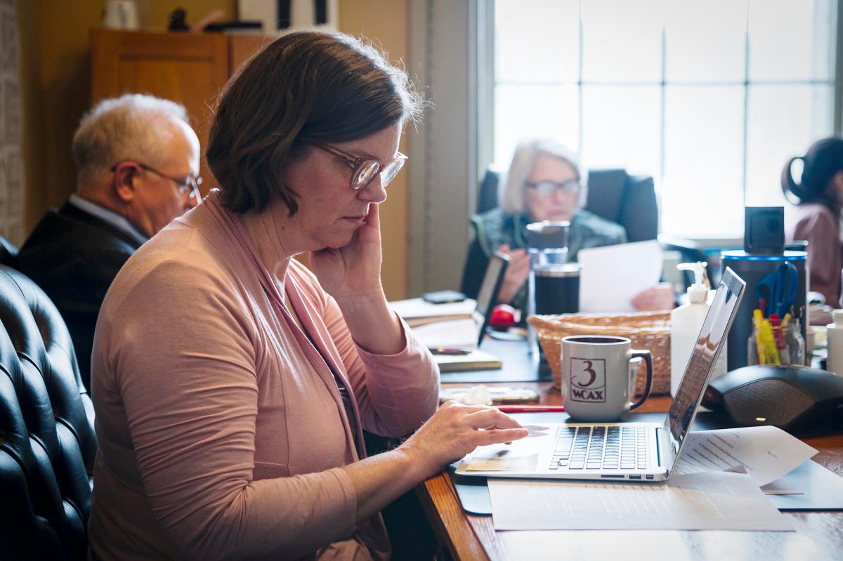 A woman working on a laptop in a meeting room.