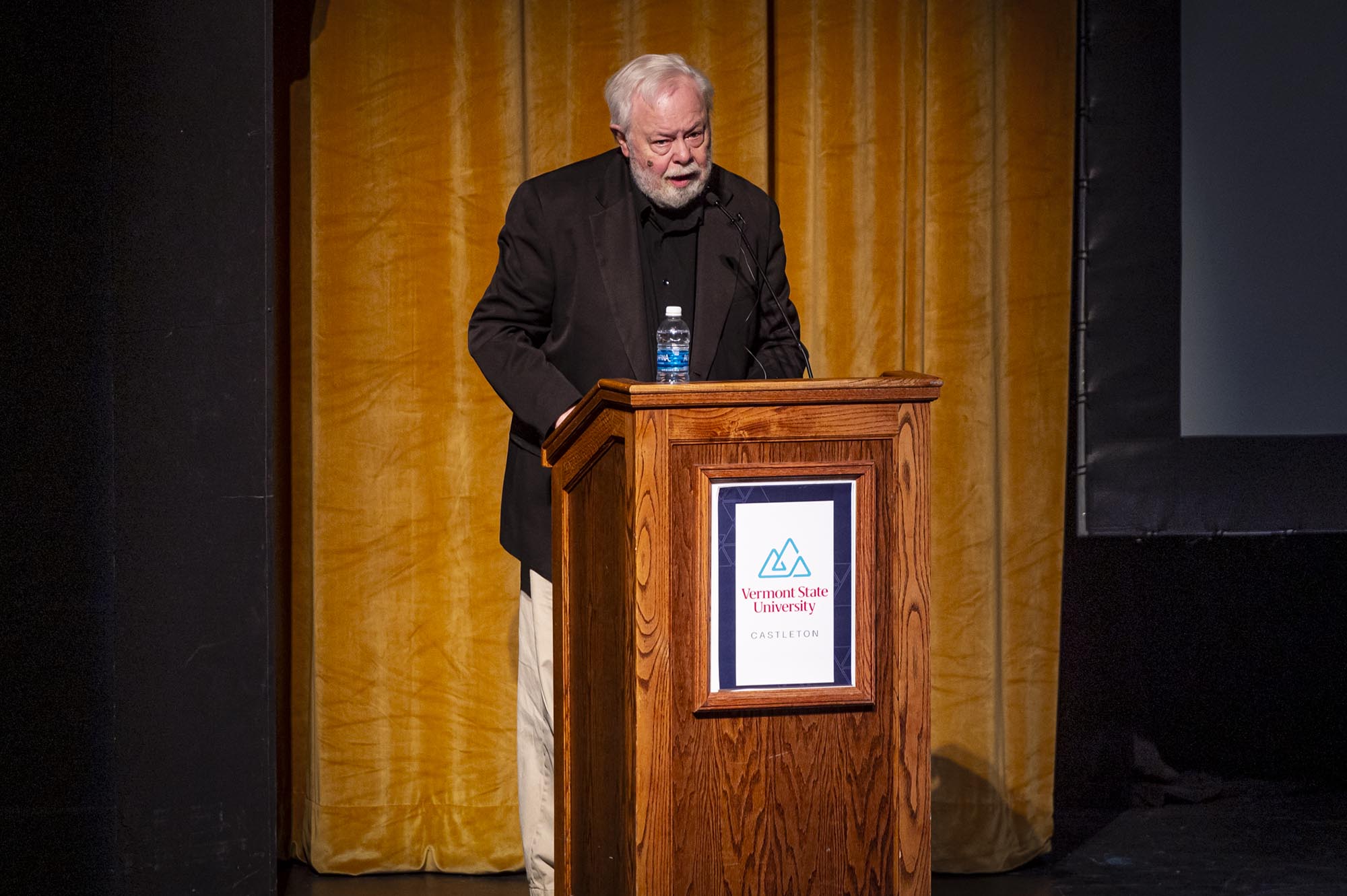 A man standing at a podium in front of a screen.