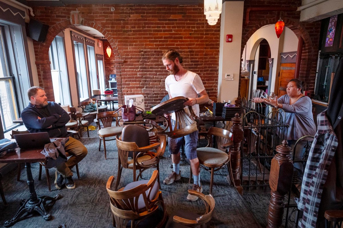 A group of people standing around a table in a restaurant.
