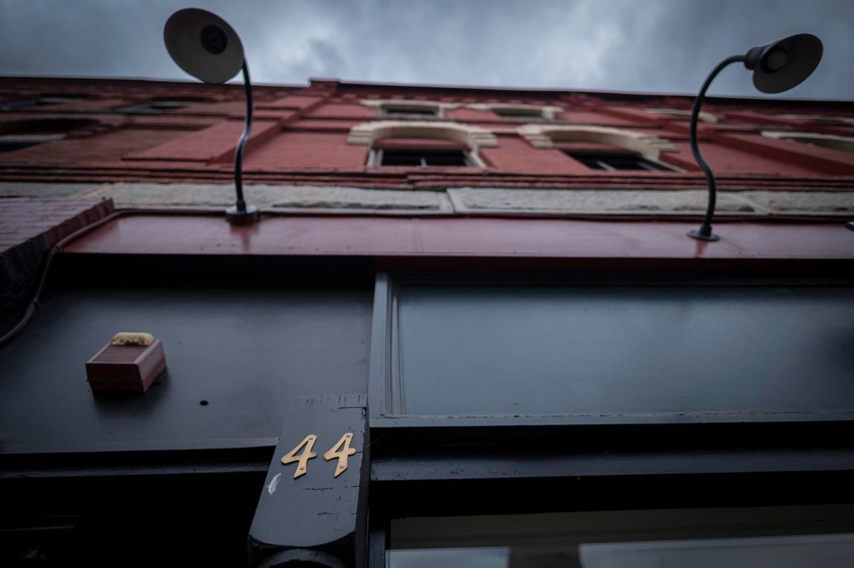 A sign on the side of a building with the number 44 on it.