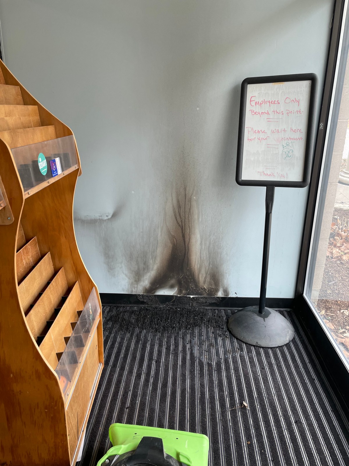 A room with a black wall and a book shelf.