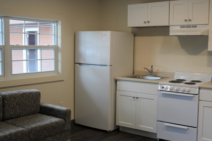 A kitchen with a refrigerator, stove, and sink.