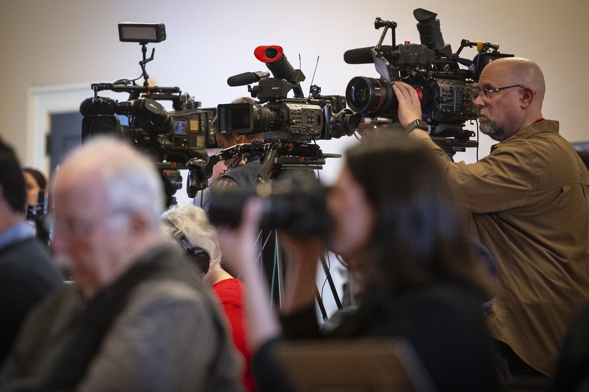 A group of people with cameras in front of them.