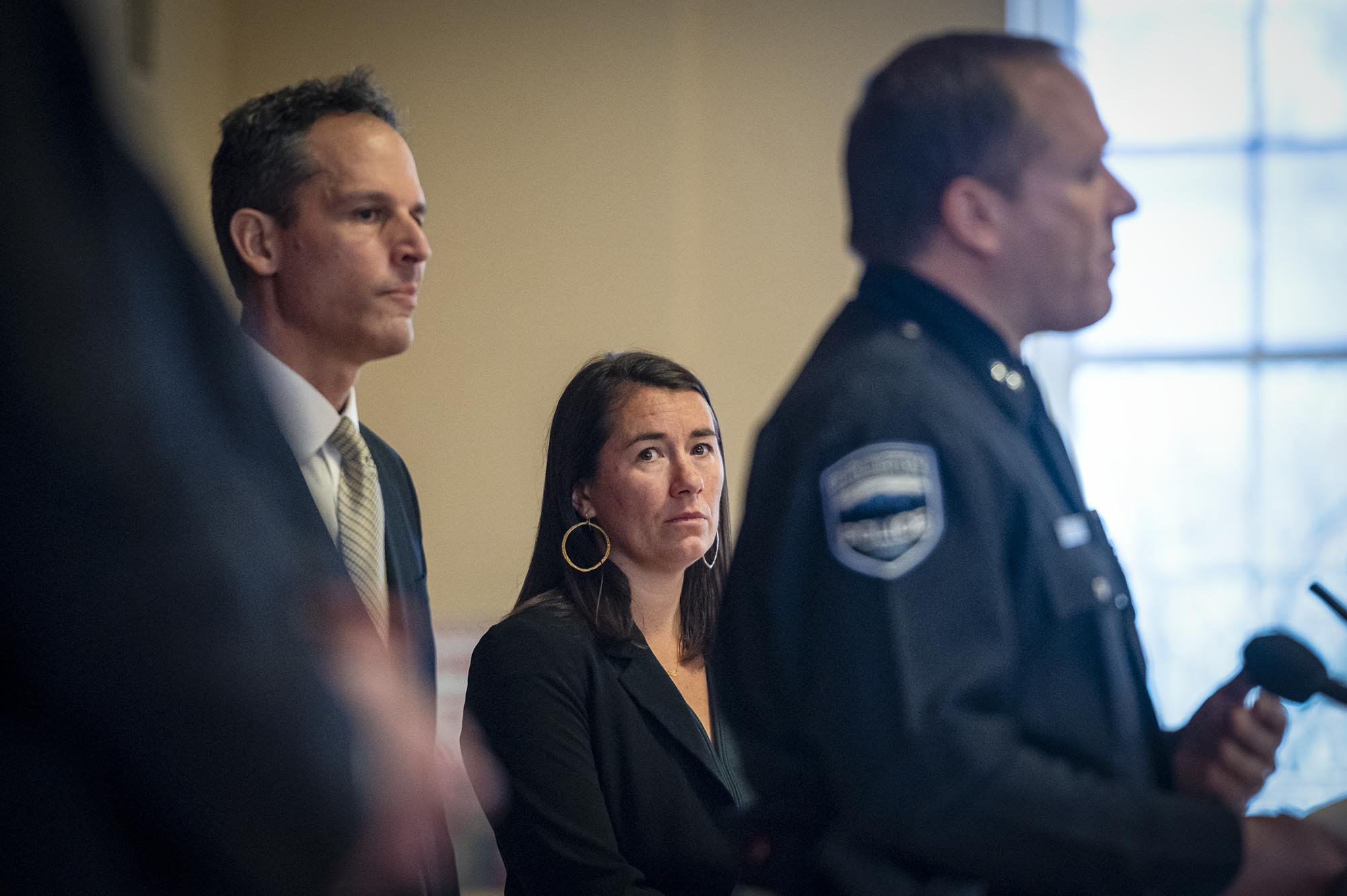 Two police officers standing next to a woman.