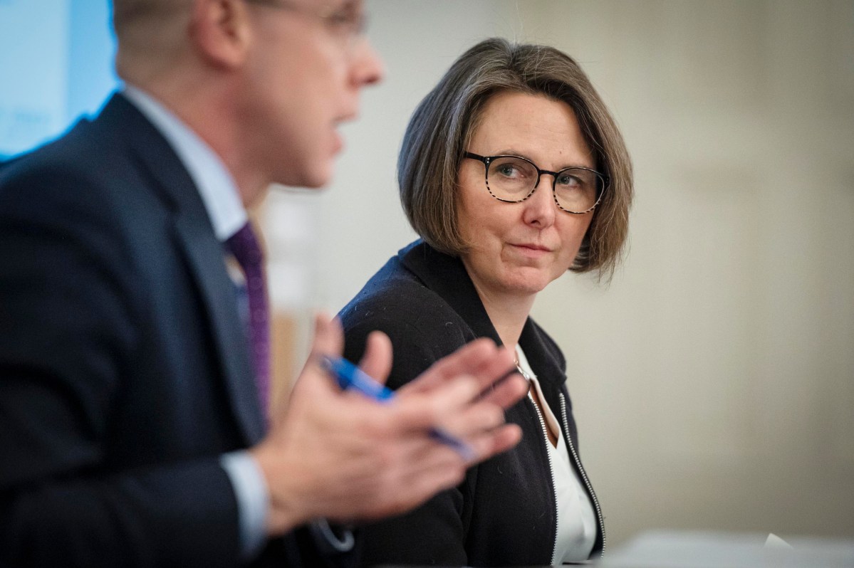 Two people sitting at a table talking to each other.