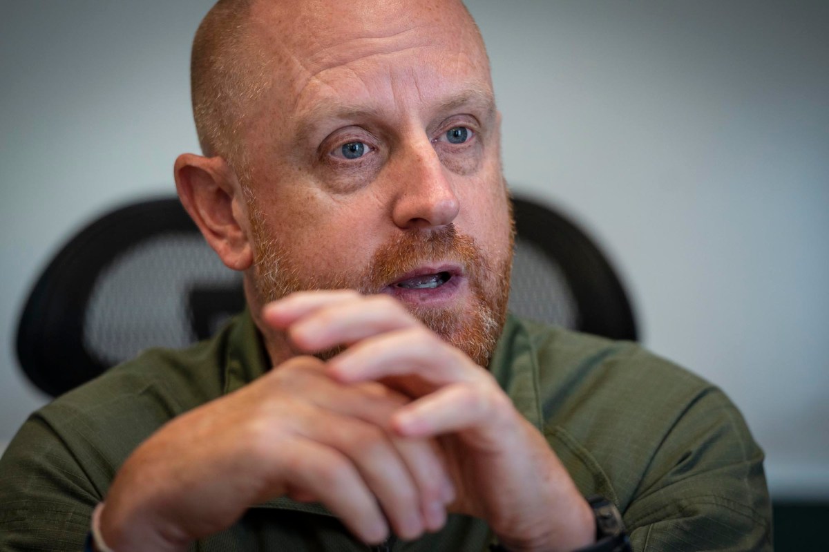 A bald man in a green shirt is talking.