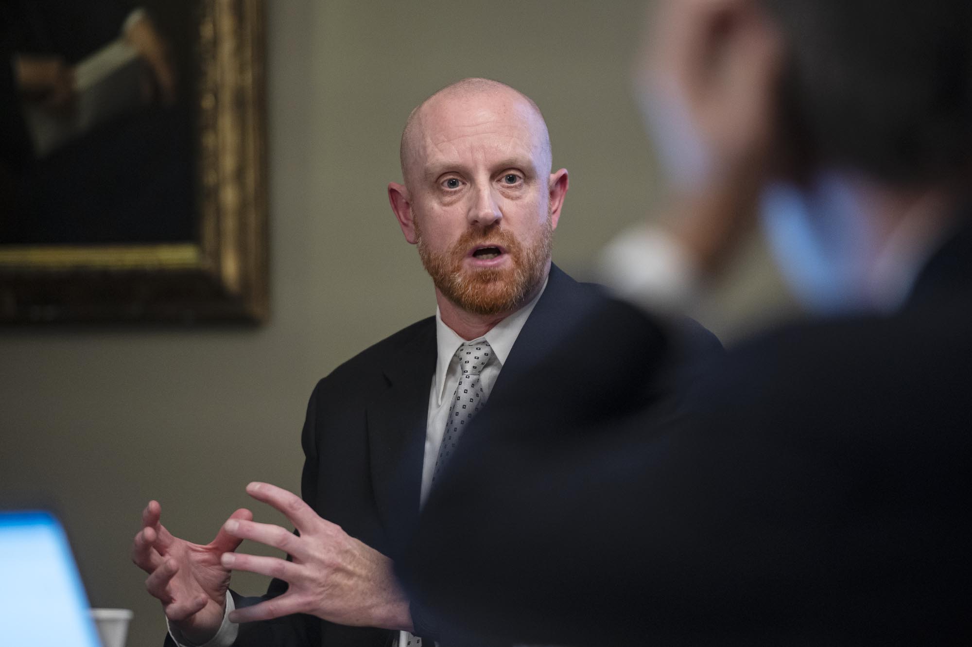 A man in a suit sitting at a table.