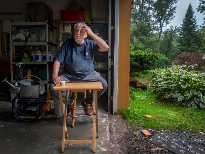 A man sitting on a table in a garage.