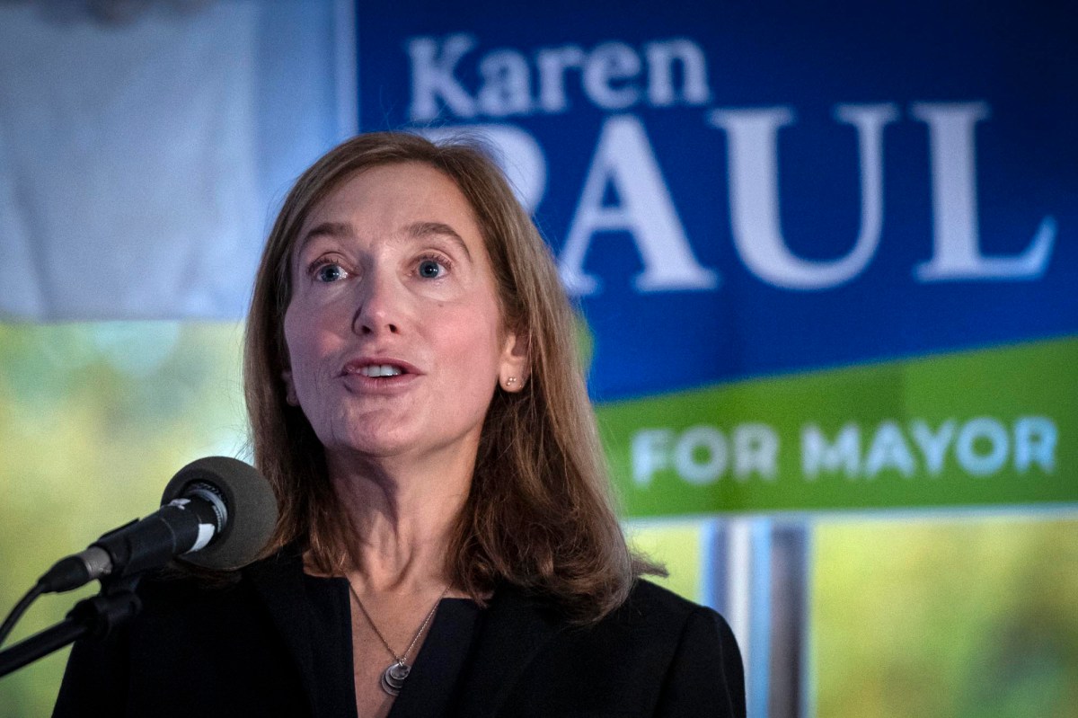 A woman speaking into a microphone in front of a crowd.