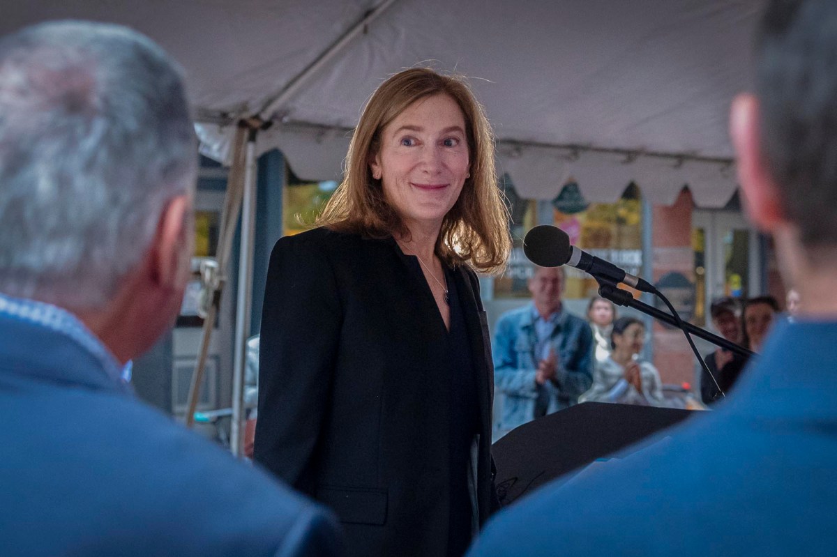 A woman is standing in front of a microphone.