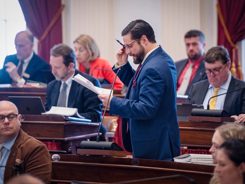 A man in a suit holding a pen and paper.