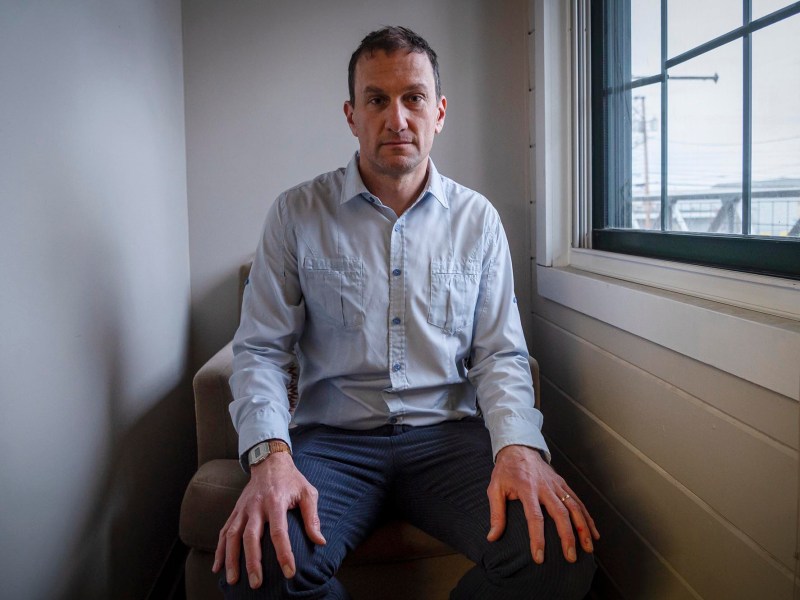 A man sitting on a chair in front of a window.