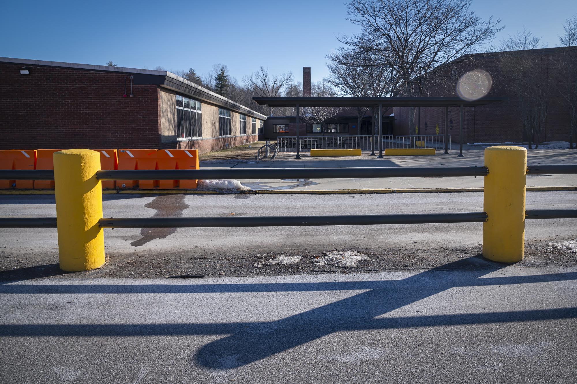 A school building with a yellow fence in the background.