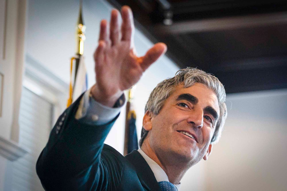 A man in a suit and tie waving his hand.