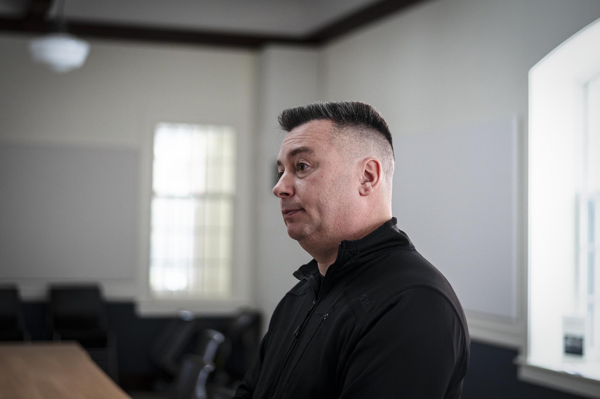 A man in a black shirt standing in a room.