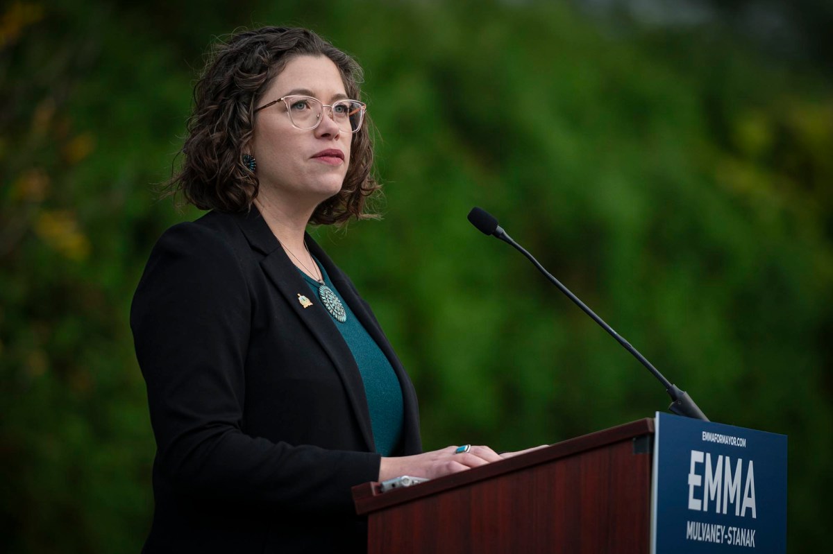 A woman in glasses standing at a podium.