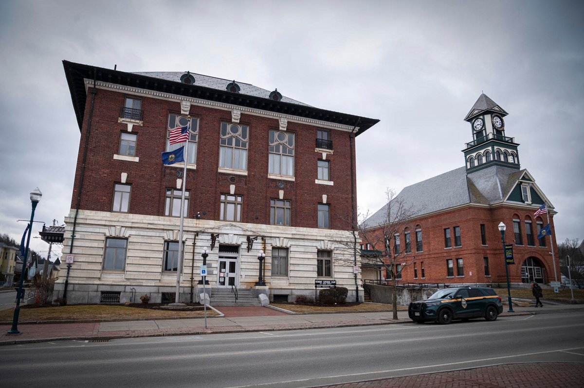 Historic town hall with clock tower under overcast skies.