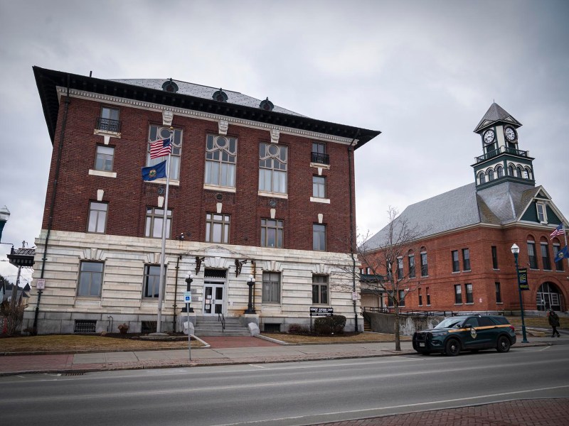 Historic town hall with clock tower under overcast skies.