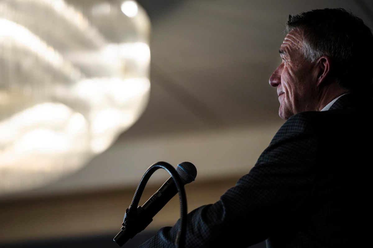 A man in a suit speaking into a microphone.