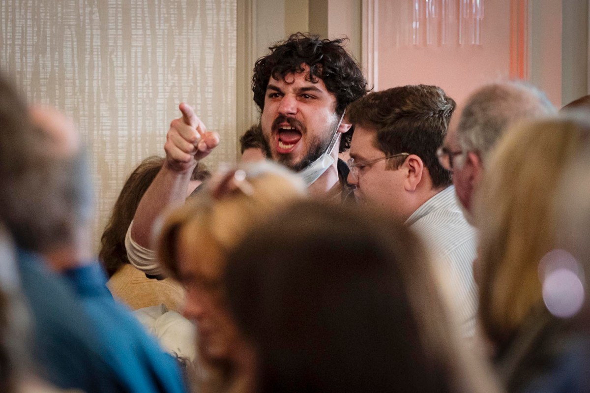 A man yelling at a crowd of people.