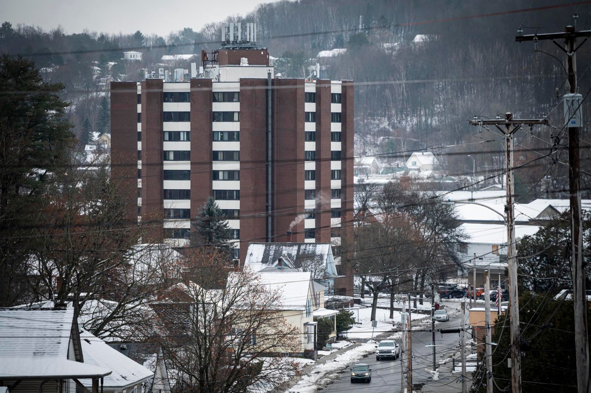 A snow covered street with a building in the background.