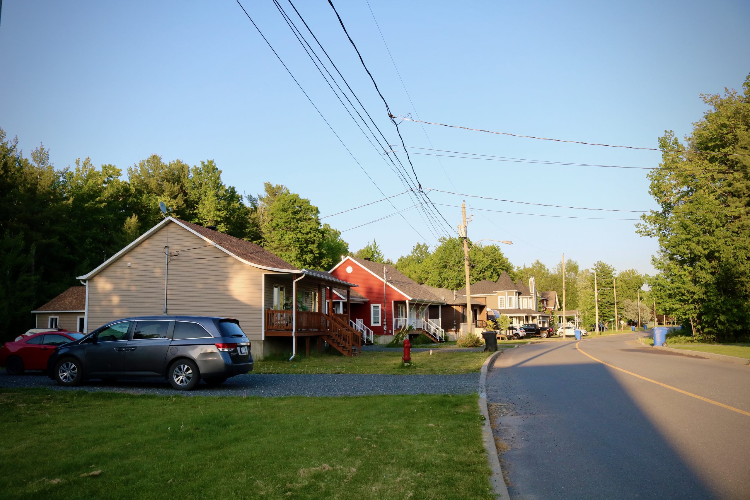 A row of houses and cars on a street.