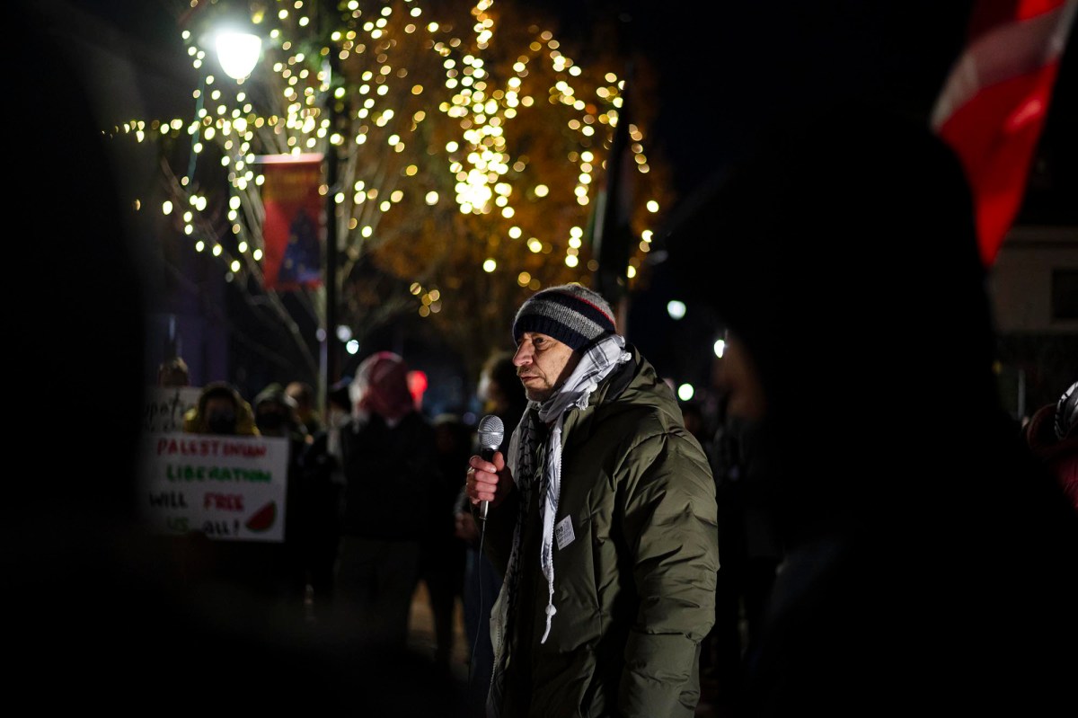 A man speaking into a microphone in front of a crowd of people.