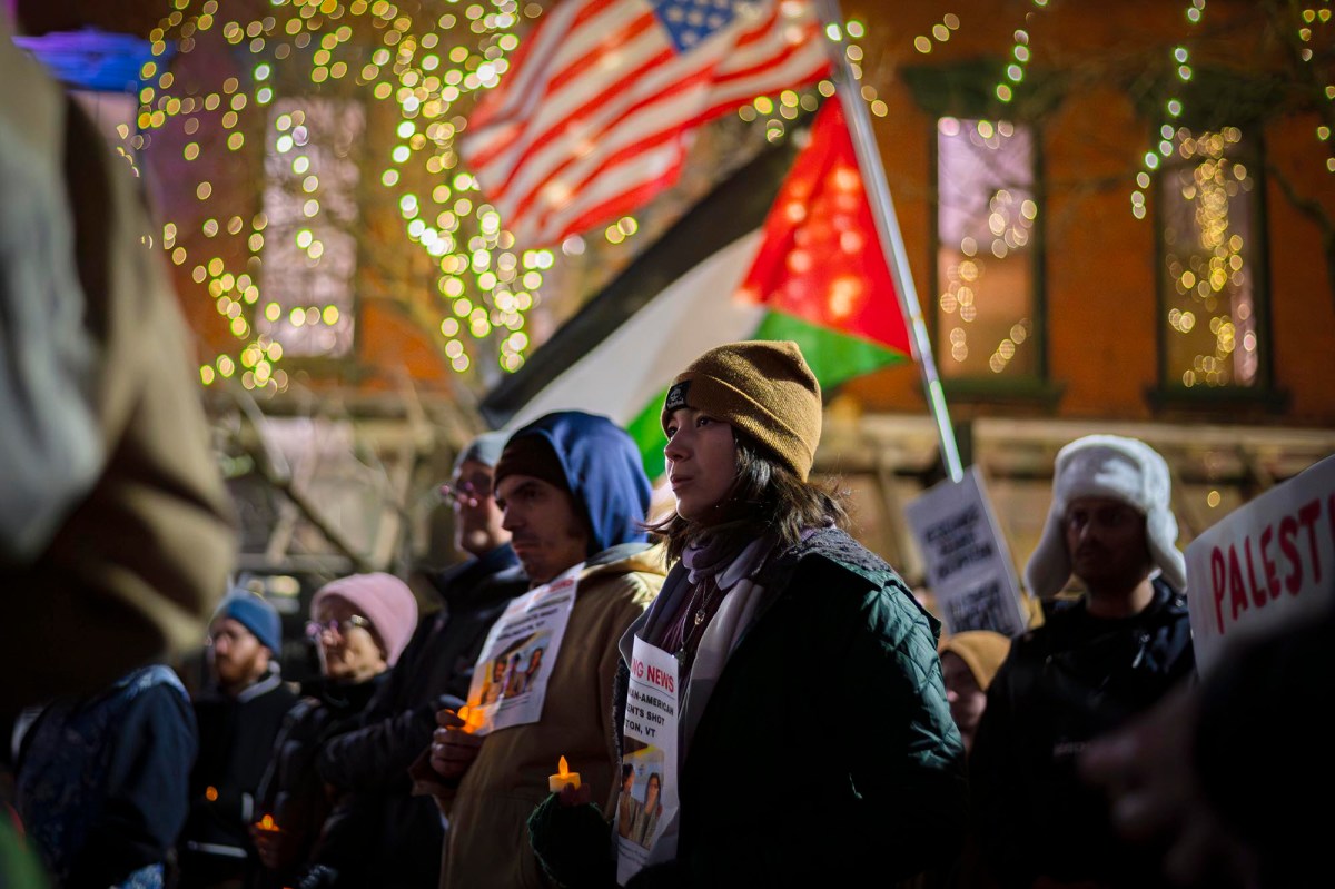 A group of people holding candles in front of a building.