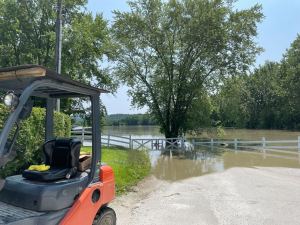 a forklift is parked next to a flooded road.