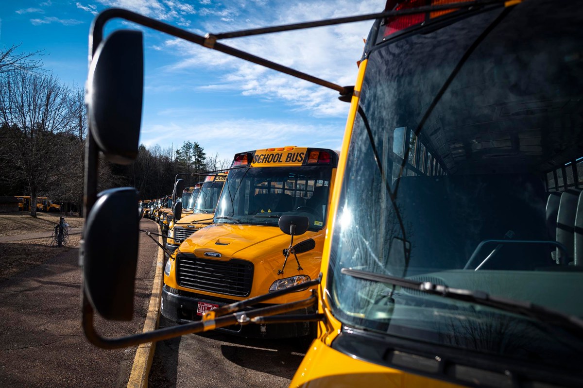 A row of yellow school buses parked next to each other.