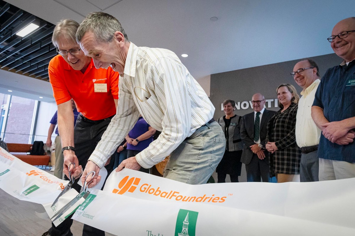 A group of people cutting a ribbon in front of a building.