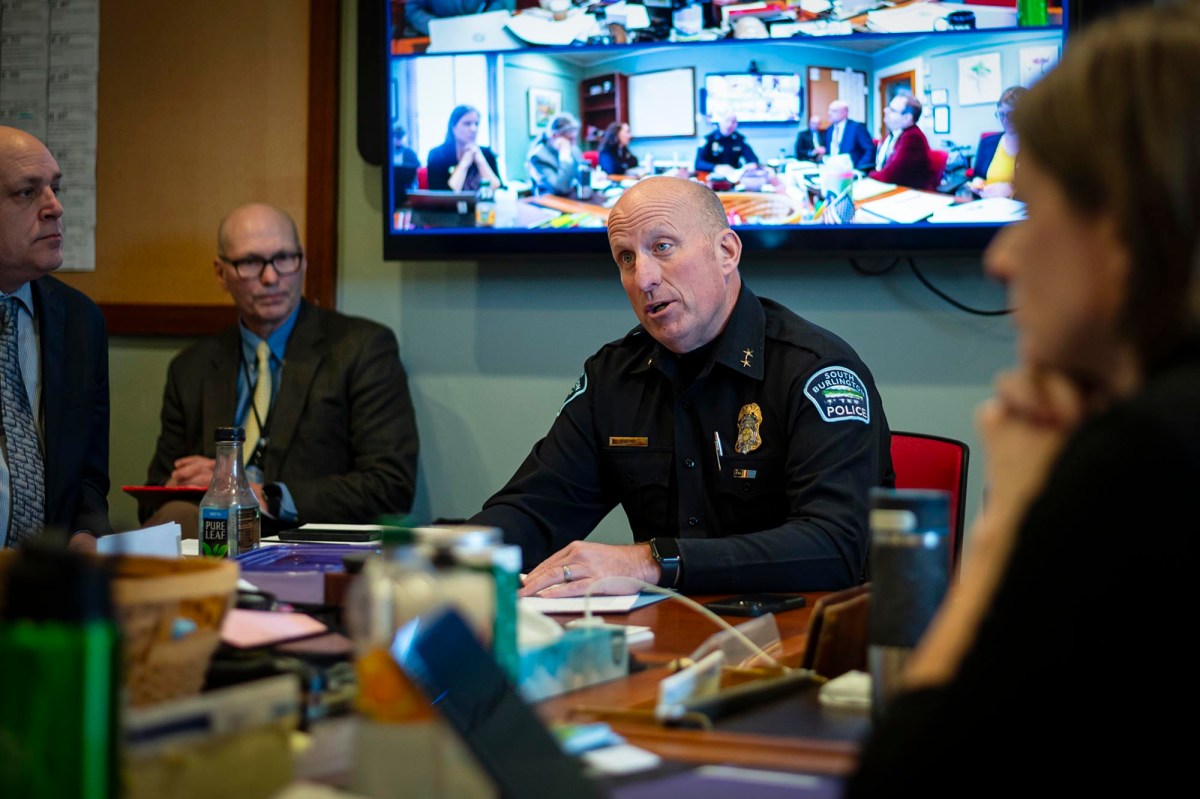 A police officer sits at a table with a group of people.