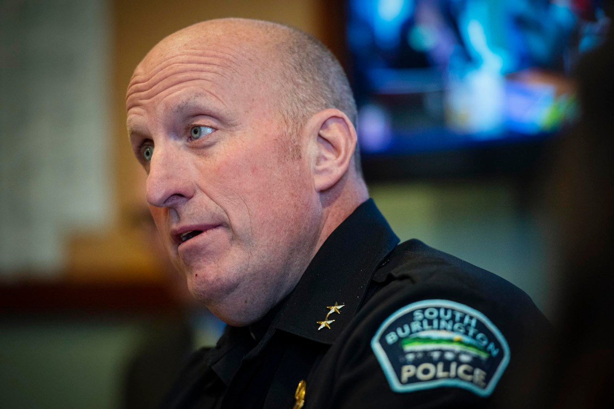 A police officer is sitting in front of a tv.