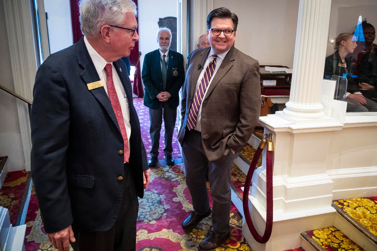 Two men in suits talking to each other in a room.