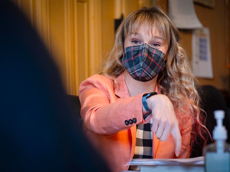 A woman wearing a face mask at a meeting.