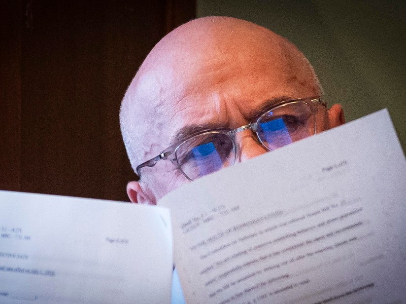 A bald man looking at a piece of paper.