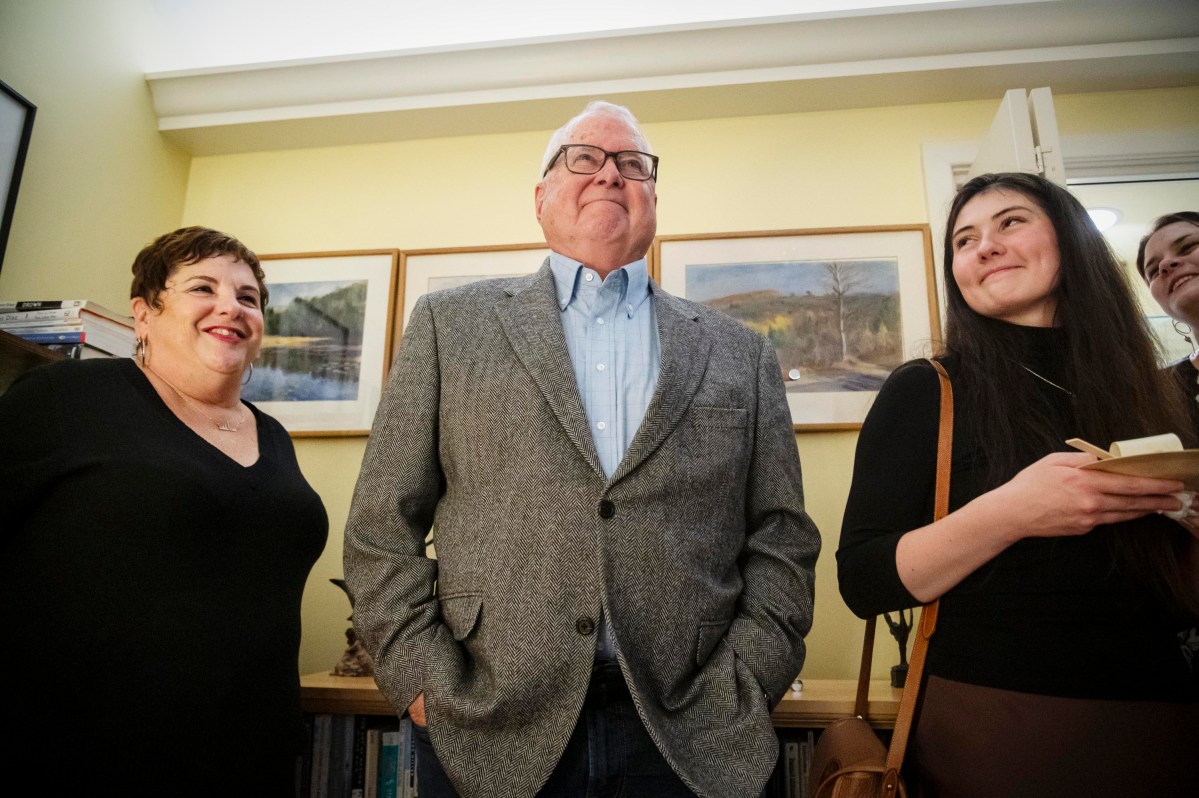 A group of people standing in a room with a man.