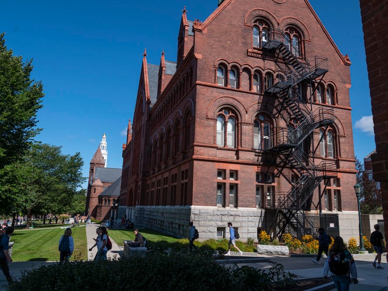 A large red brick building with people walking in front of it.
