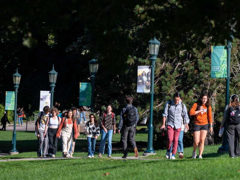 A group of students walking on a grassy area.