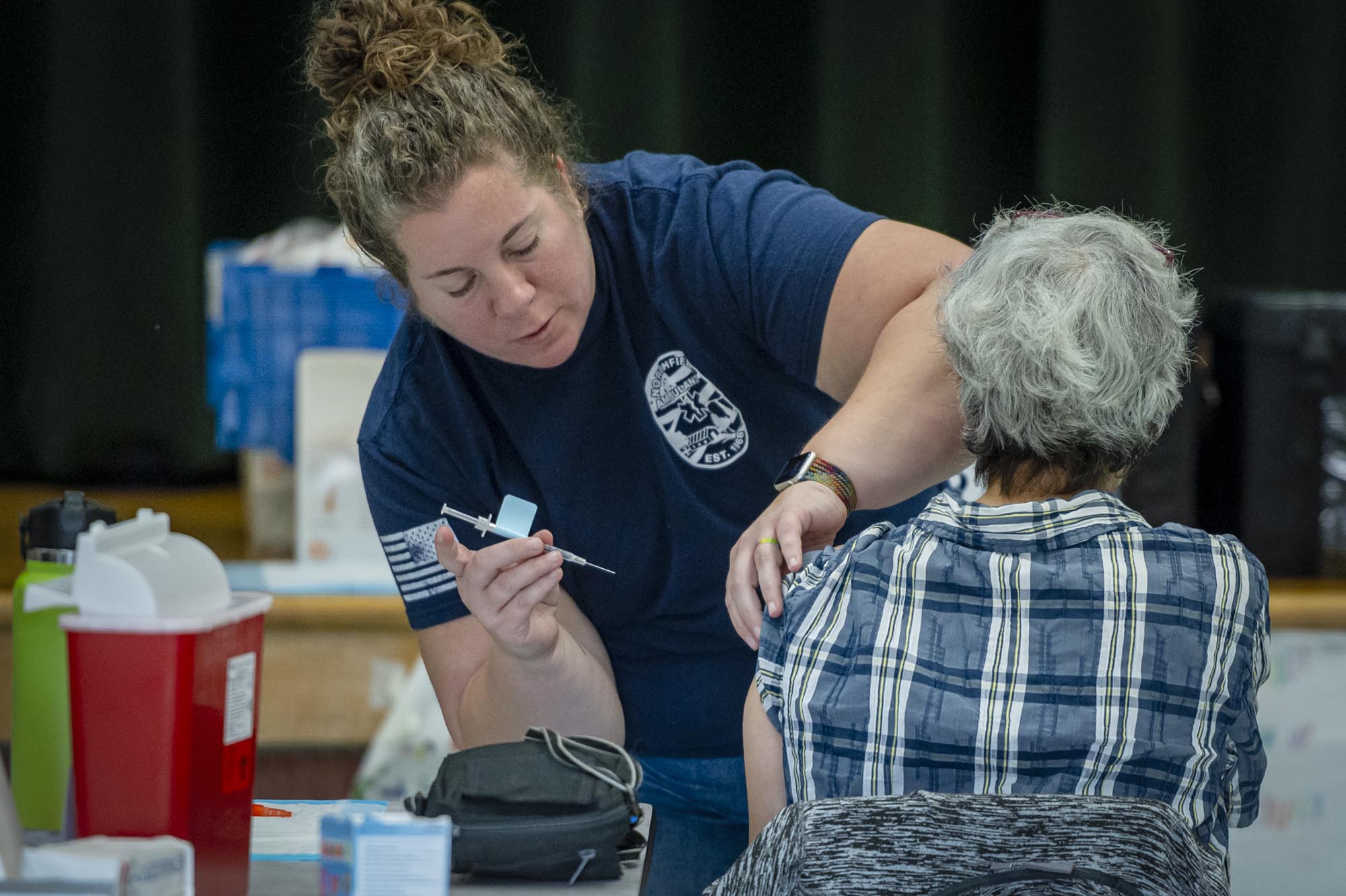 A woman is giving a woman a shot.
