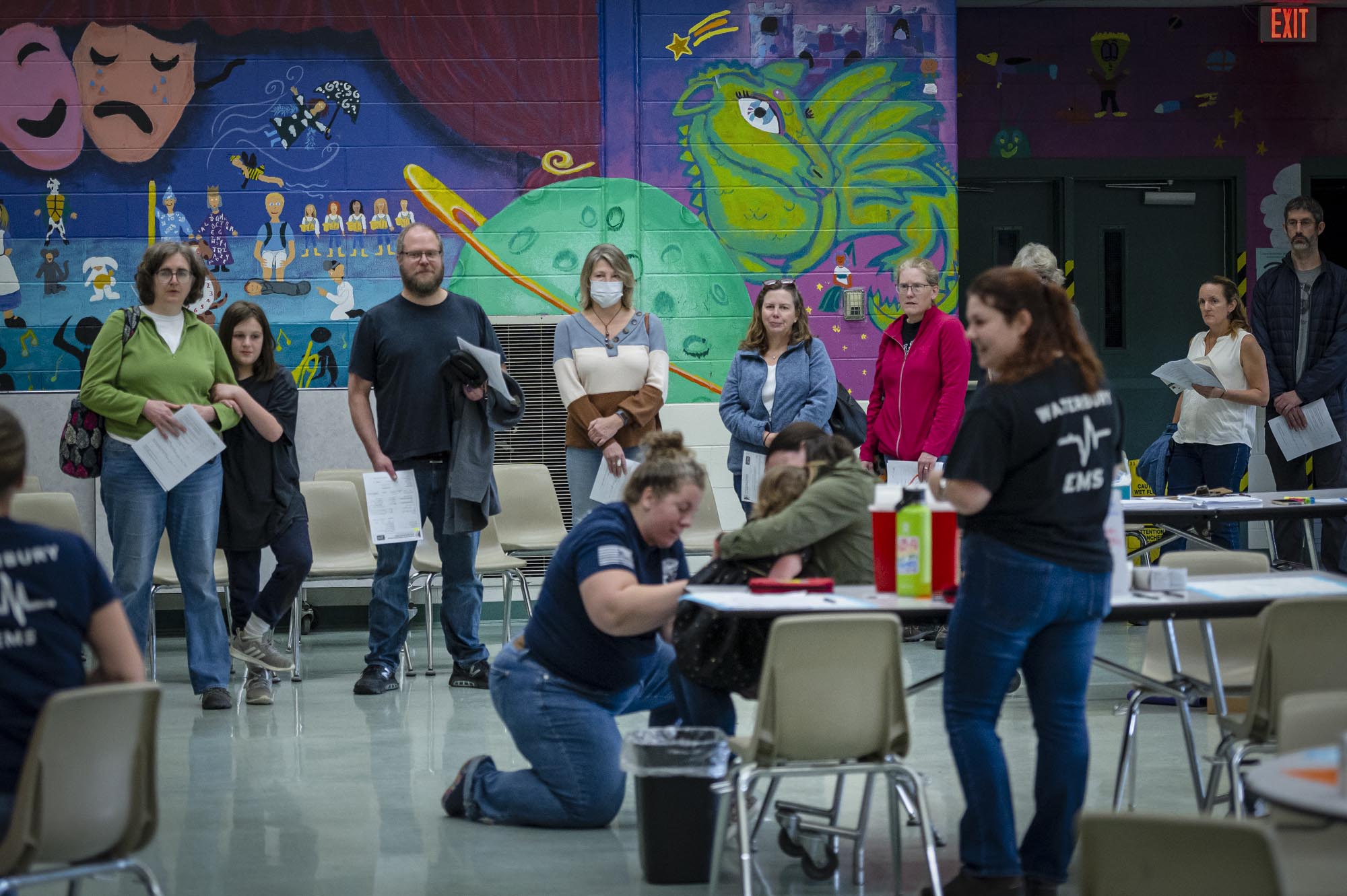 A group of people standing around a table in a classroom.
