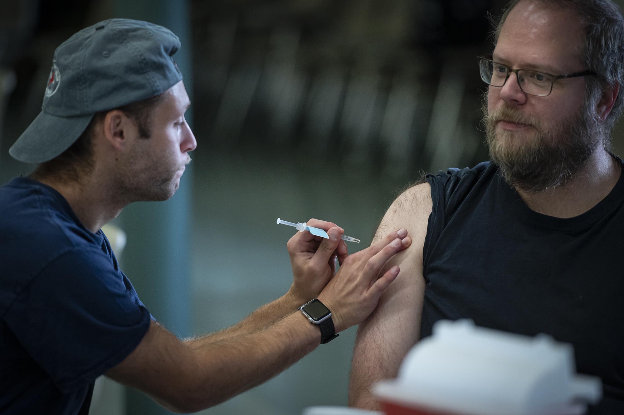 A man is getting a vaccine from another man.