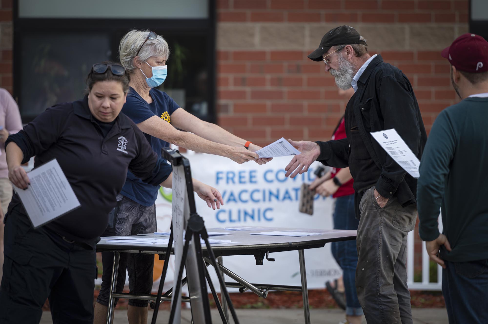A group of people handing out papers at a table.