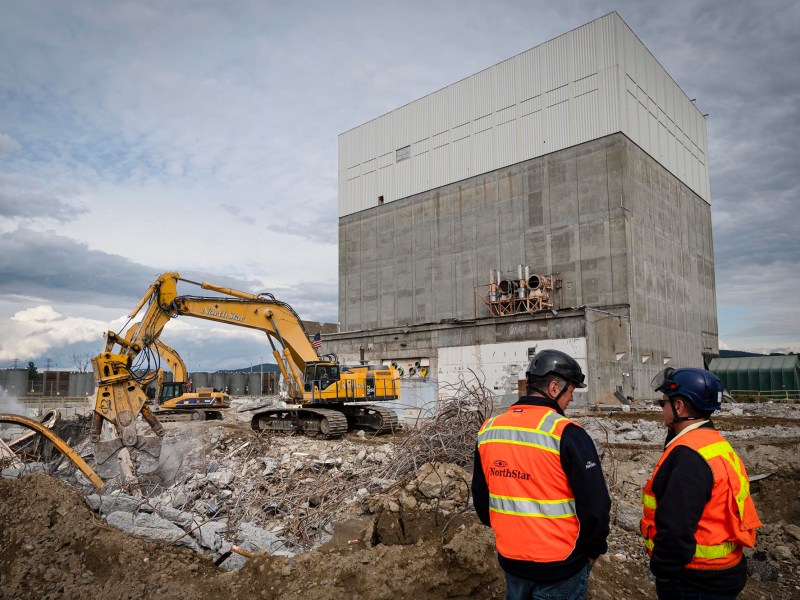 A group of construction workers standing in front of a large building.