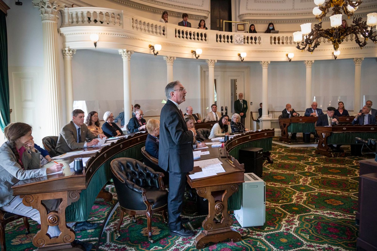 a group of people sitting at desks in a room.