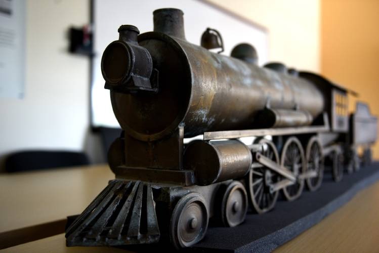 A close-up view of a detailed model of an old steam locomotive displayed on a table.
