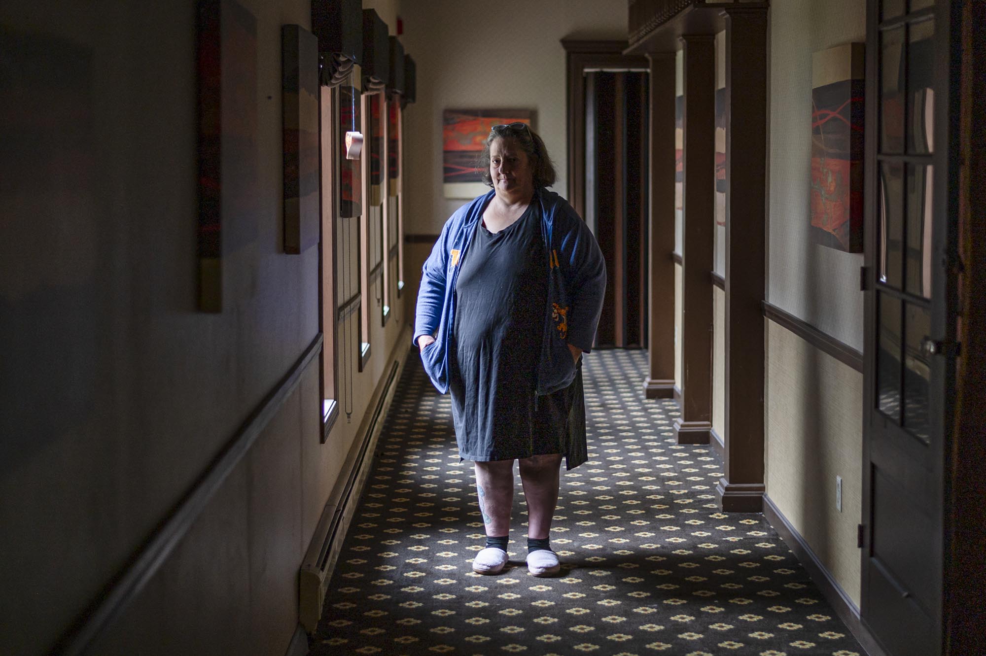 A woman standing in a hallway.