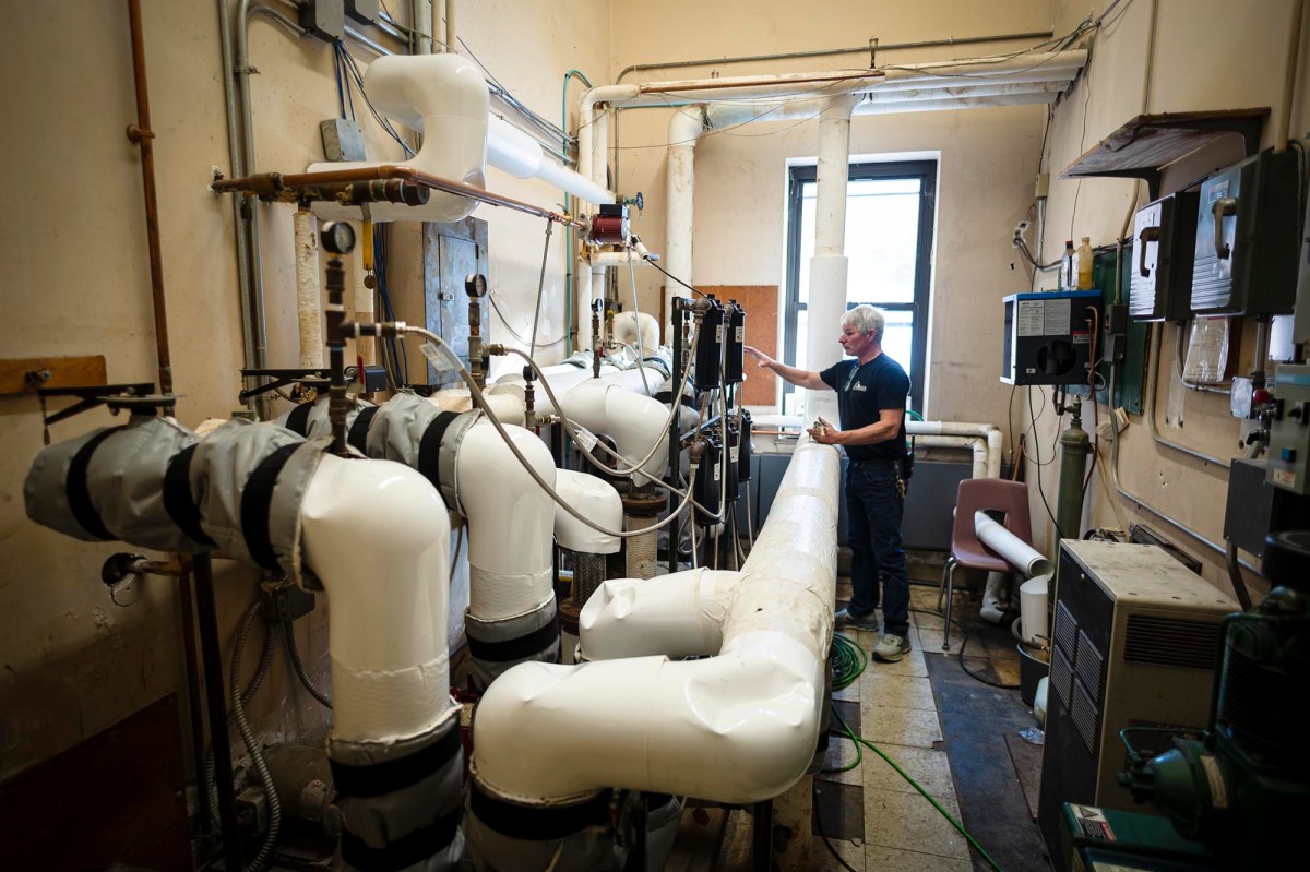 A man standing in a room with pipes and pipes.