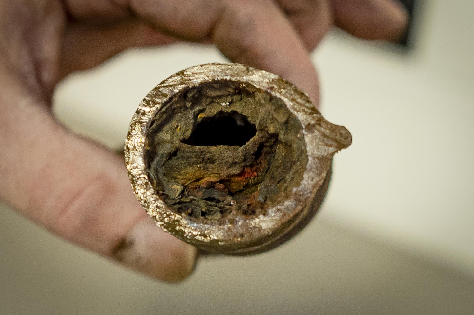 A person holding a pipe with a hole in it.